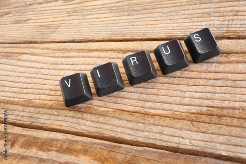 "VIRUS" wrote with keyboard keys on wooden background
