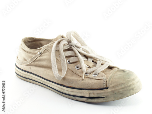 single beige canvas shoes isolated on white, old extreme sport sneakers