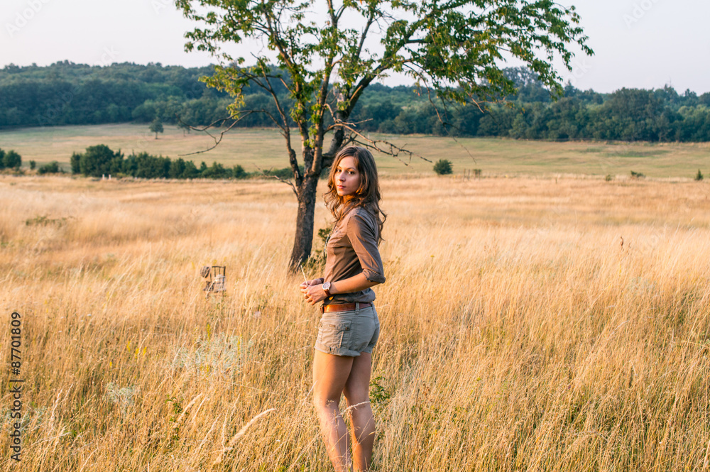 Beautiful girl in summer field in safari style