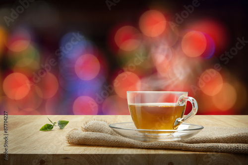 Cup of tea with sacking on the wooden table and the bokeh backgr