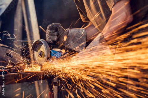 Fotografia, Obraz Close-up of worker cutting metal with grinder