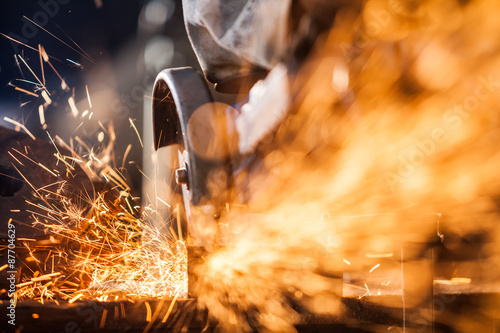 Obraz na plátne Close-up of worker cutting metal with grinder