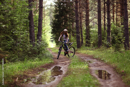 young girl on a sports bike in a summer forest © kichigin19