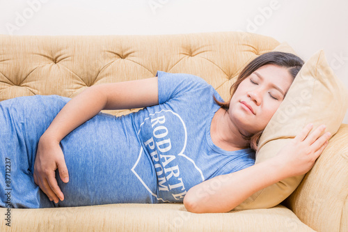 Pregnant woman relaxing at home on sofa