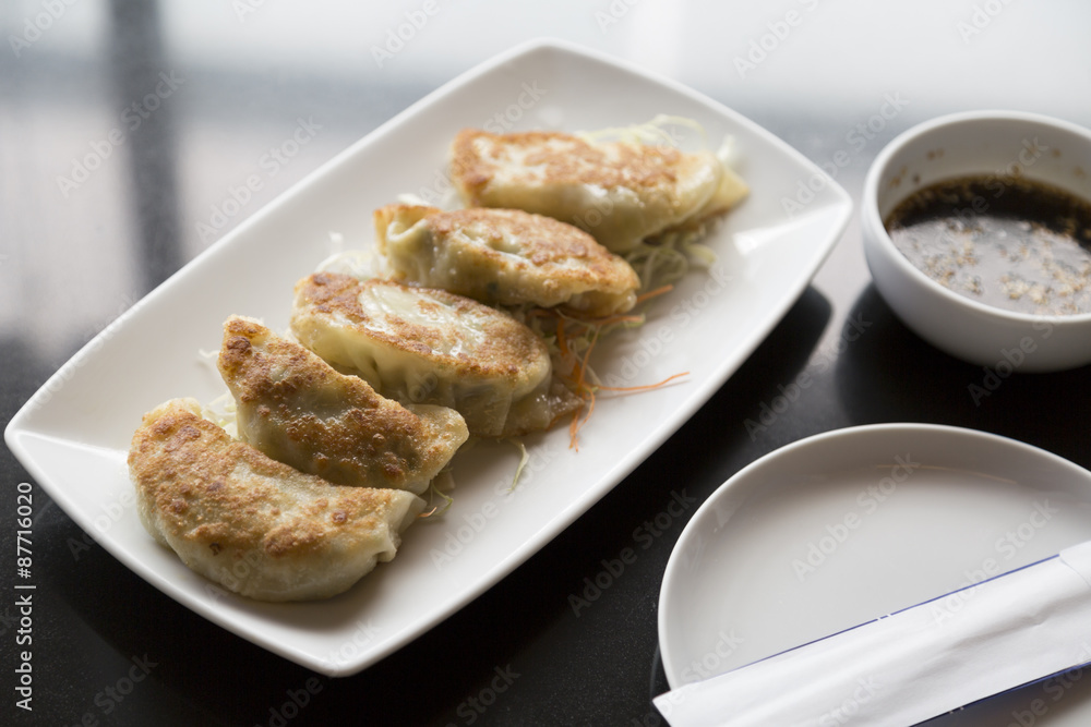 Jiaozi , Chinese dumpling on black table with sauce Jiaozi , Chinese dumpling on black table with sauce