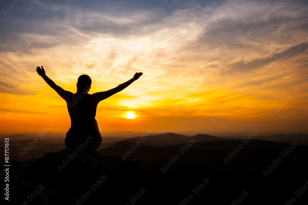 single adult woman silhouette on rock