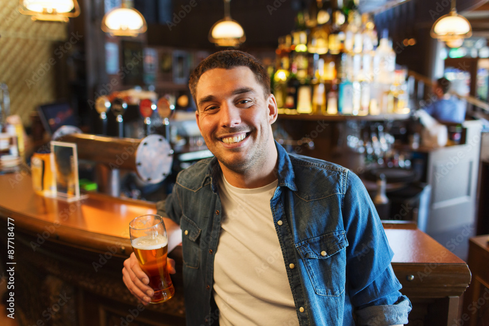 happy man drinking beer at bar or pub