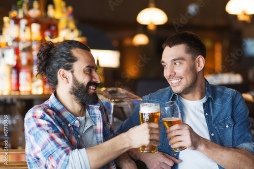 Canvas Print happy male friends drinking beer at bar or pub