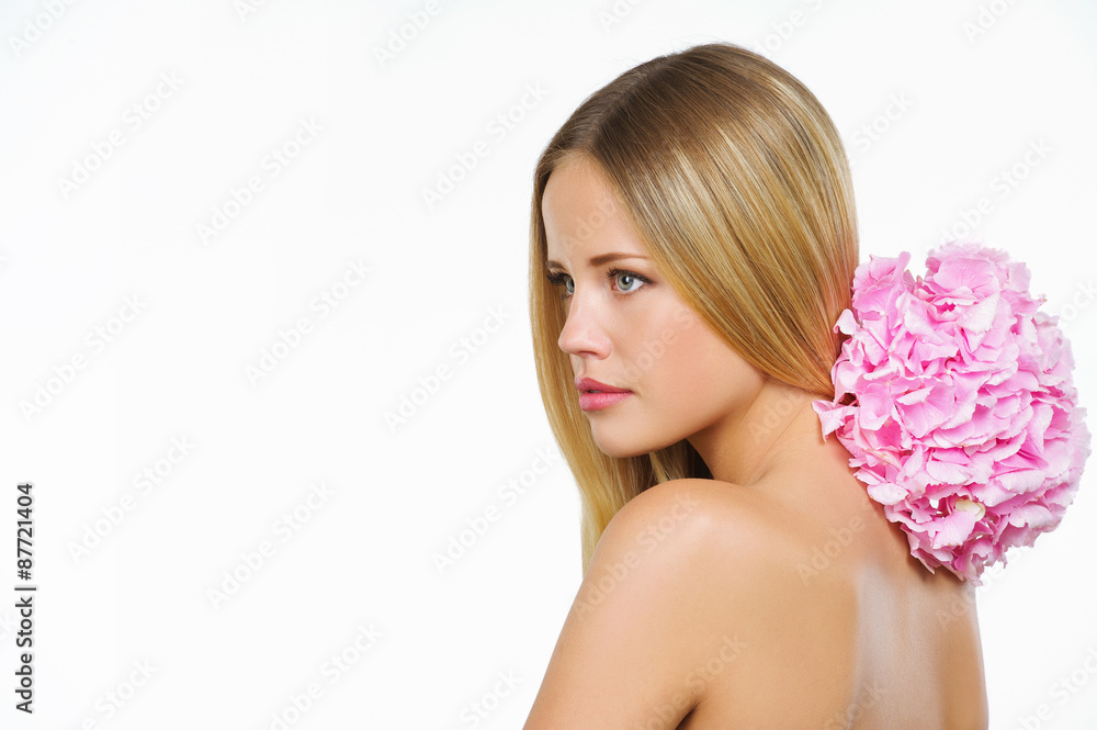 Portrait of young beautiful woman with healthy face and natural makeup posing on white background with pink flower Portrait of young beautiful woman with healthy face and natural makeup posing on white background with pink flower