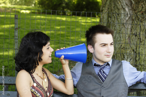 Man ignoring woman with megaphone.
