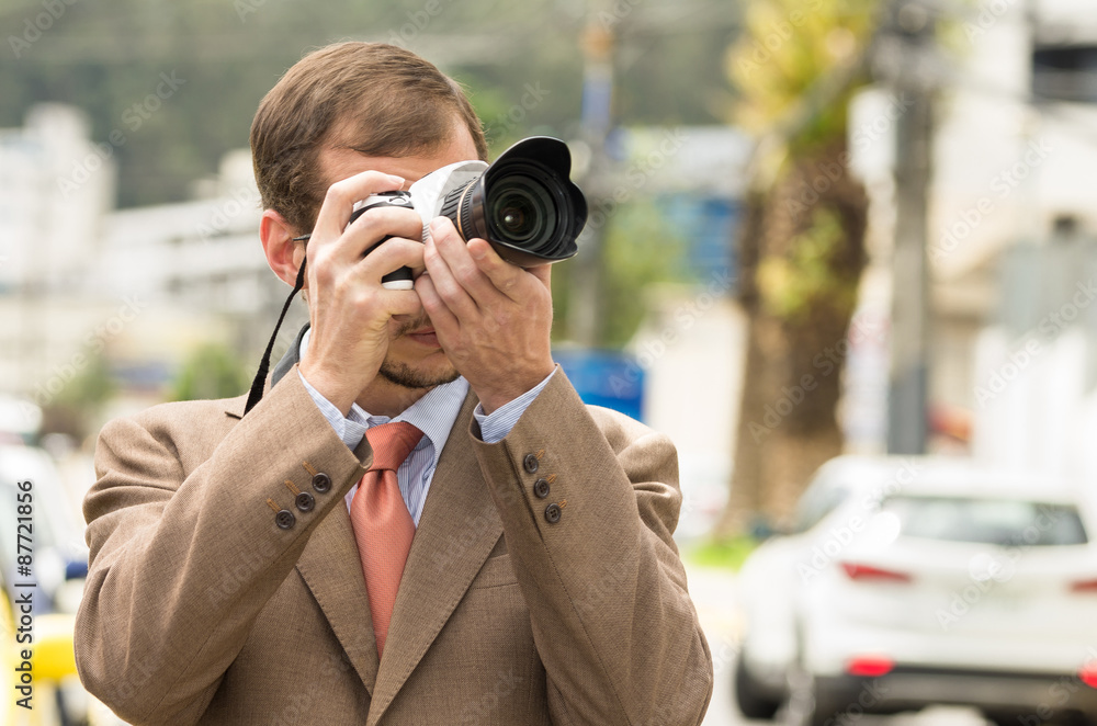 Successful attractive male photographer wearing brown suit Successful attractive male photographer wearing brown suit