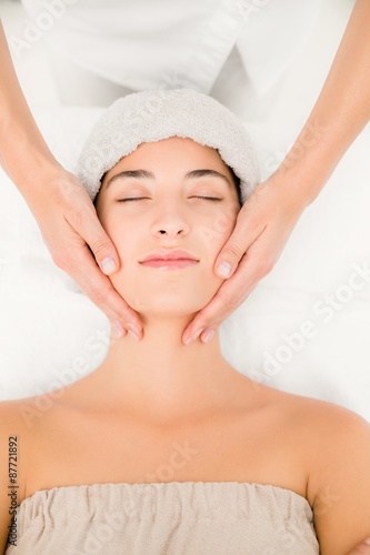 Attractive young woman receiving massage at spa center