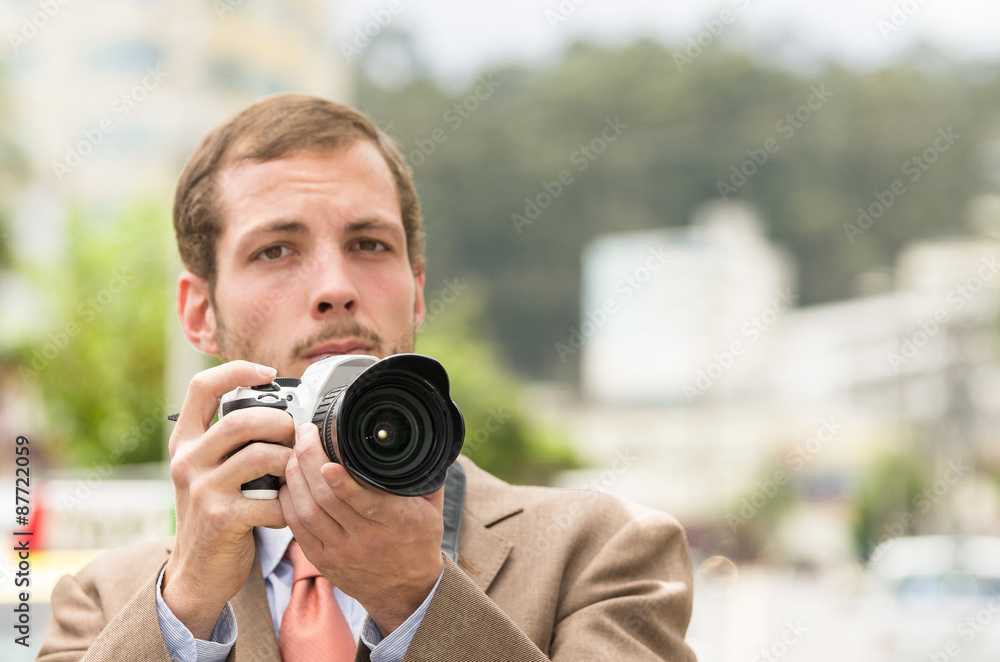 Successful attractive male photographer wearing brown suit