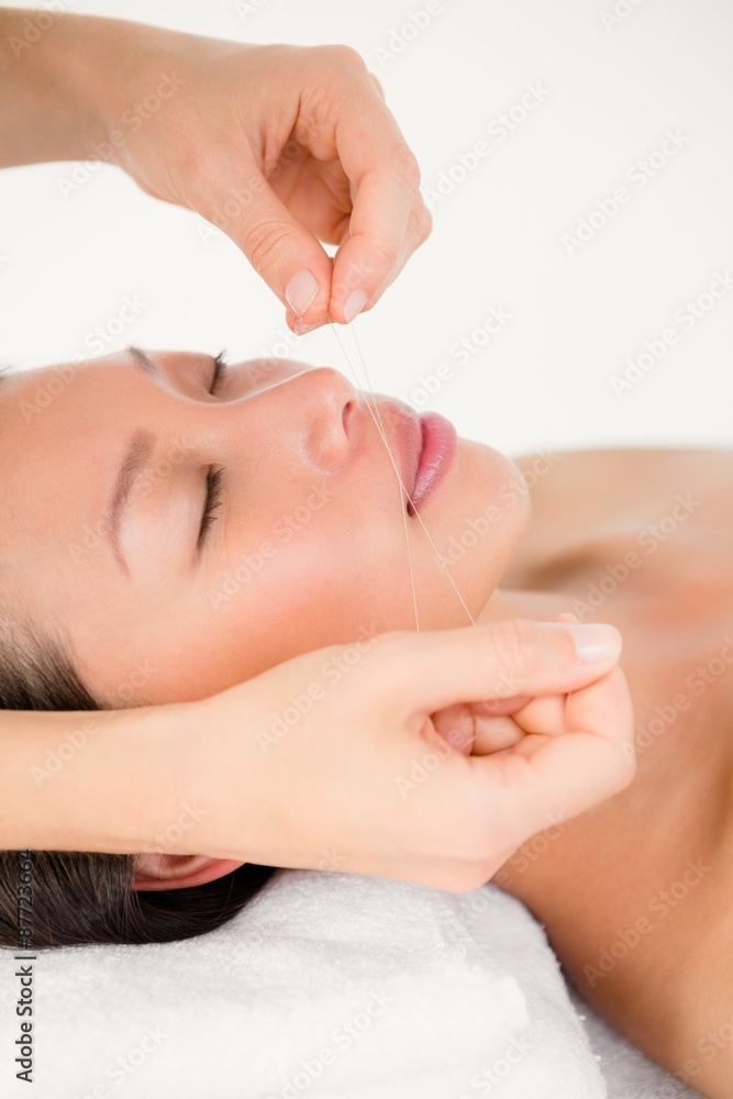 Hands threading beautiful womans face Hands threading beautiful womans face