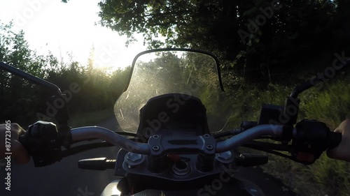 Man driving motorbike on sunset. POV, Original point of View  photo