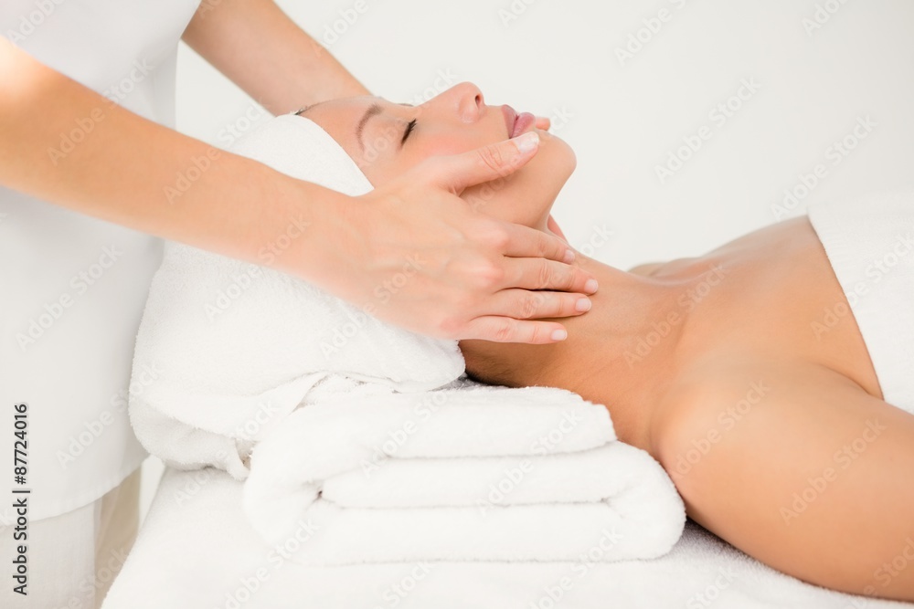 Attractive young woman receiving facial massage Attractive young woman receiving facial massage