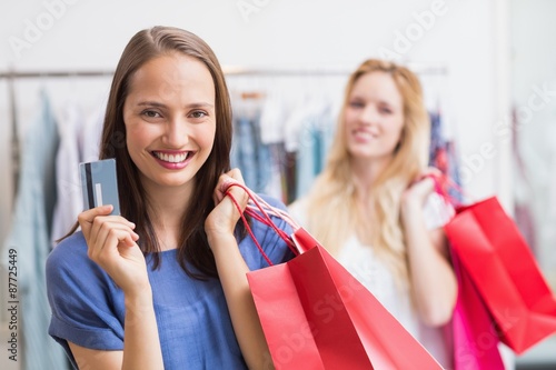 Happy friends holding a credit card