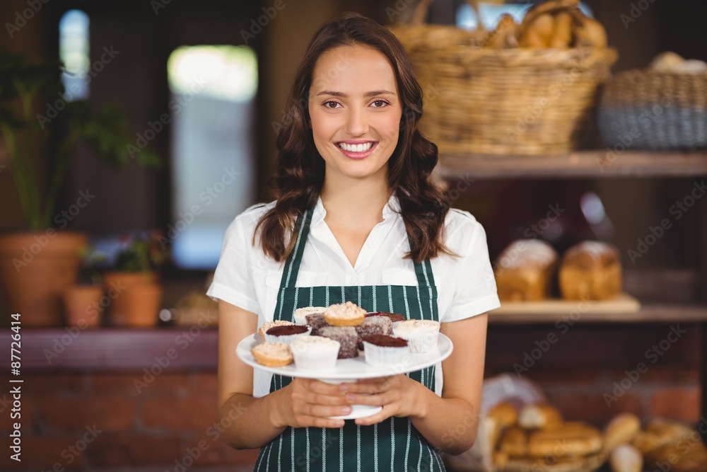Pretty waitress showing a plate of cupcakes Pretty waitress showing a plate of cupcakes