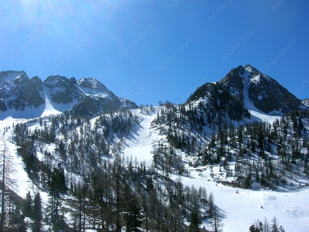Snowy winter landscape in the mountains, in the French ski resort Isola 2000 in the Alps, on a sunny day.