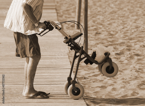 man walking with Walker on the beach in summer