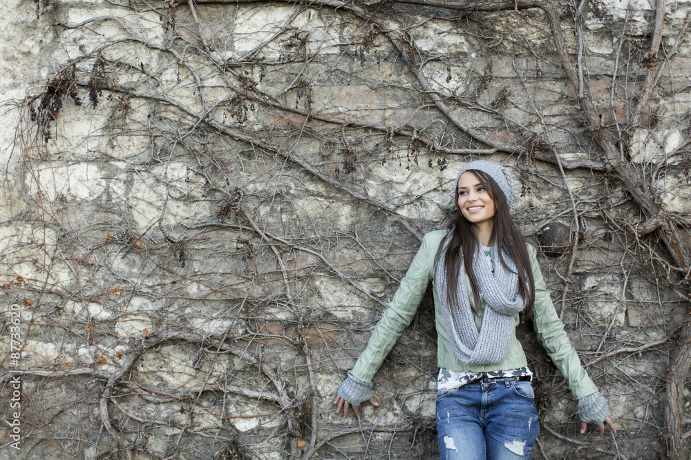 Young woman by the wall at autumn Young woman by the wall at autumn