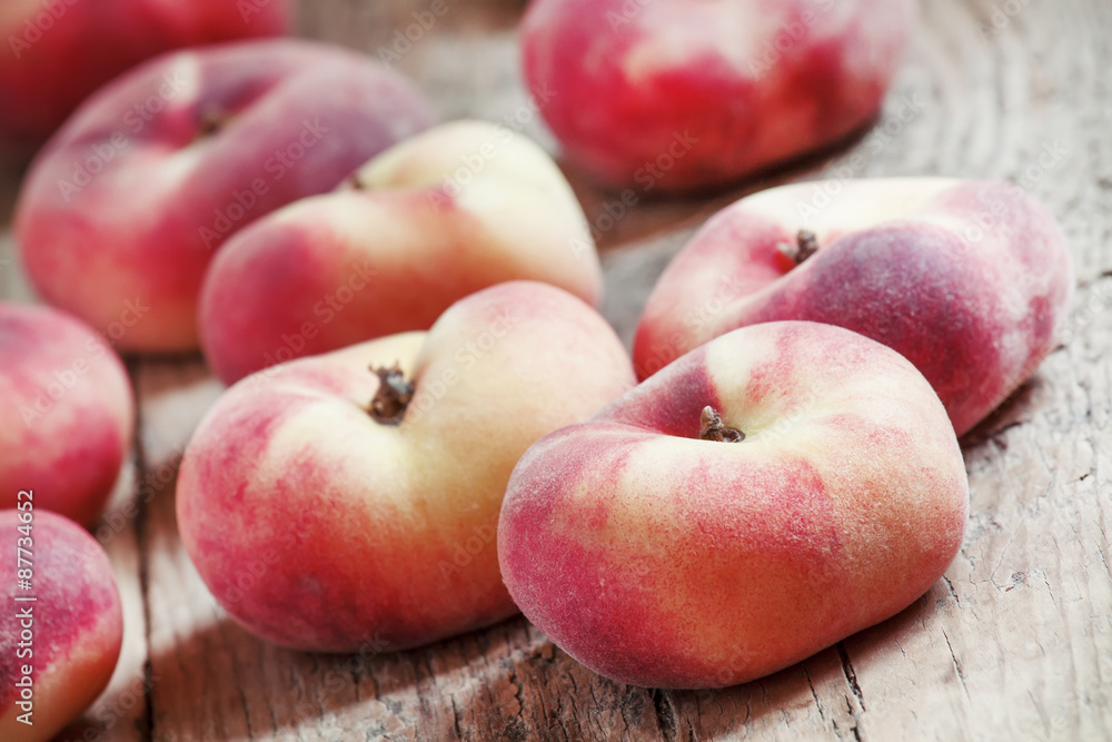 Flat pink peach on an old wooden background, selective focus Flat pink peach on an old wooden background, selective focus