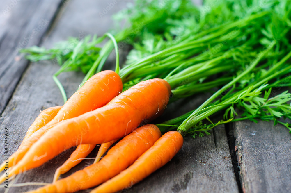 Bunch of fresh washed carrot on the old wooden background Bunch of fresh washed carrot on the old wooden background