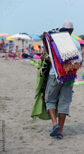 African peddler of towels and beach towels on the beach
