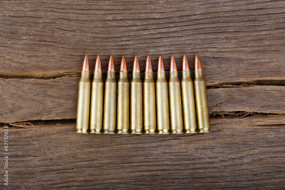 Rifle bullets on wood table.