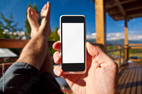 Man with smartphone in his hand on balcony. Point of view.