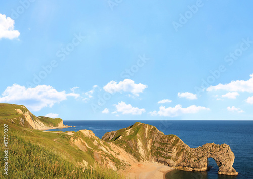 Küstenlandschaft Südengland mit Felsentor, blauer Himmel mit F © SusaZoom