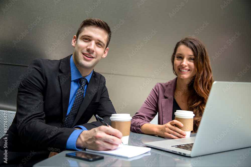 Proud happy company founders at workplace with coffee laptop in suits portrait Proud happy company founders at workplace with coffee laptop in suits portrait
