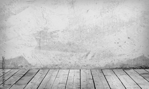 Room with a concrete wall and wooden floors.