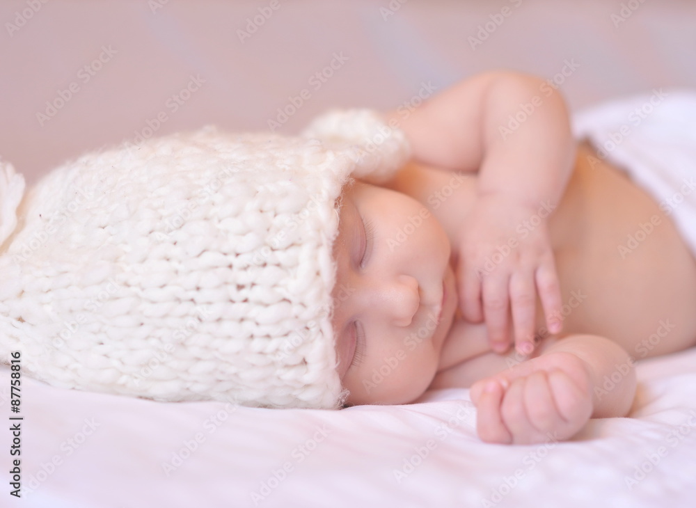 Sleeping cute baby with knitted hat in bed. Childhood. Sleeping cute baby with knitted hat in bed. Childhood.