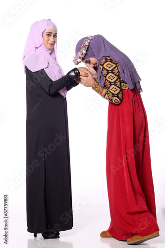 two musliman woman "bersalam" or shake hand gesture for Malay races