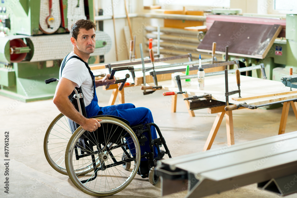 worker in wheelchair in a carpenter's workshop worker in wheelchair in a carpenter's workshop