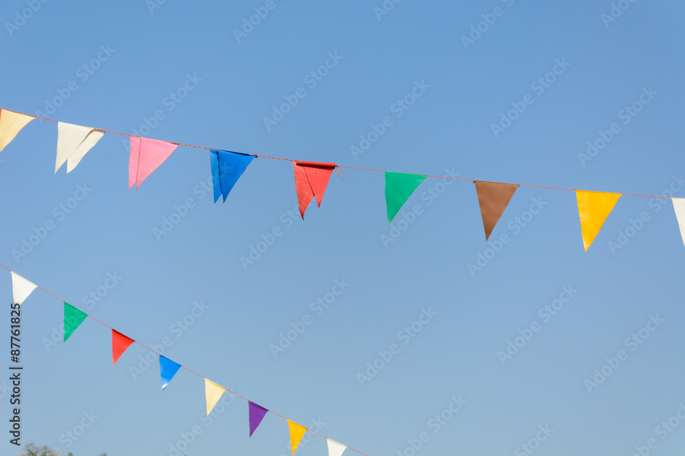 colorful festive bunting flags against a blue sky background colorful festive bunting flags against a blue sky background