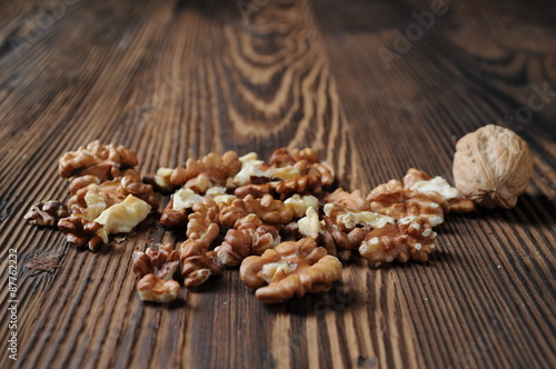 Walnut kernels and whole walnut on rustic old wooden table