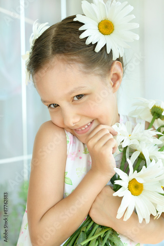 Little girl with dasies flowers photo