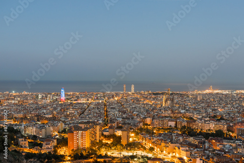 Top view and night photography of an illuminated Barcelona. The panorama shows the famous Sagrada Familia, the illuminated Torre Agbar and the Towers of the Port Olimpic until the harbor 