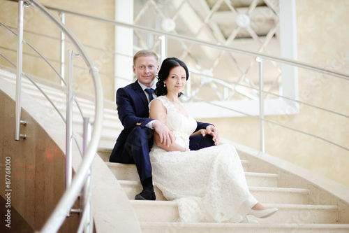 bride and groom sitting on the stairs © Evgeniy Kalinovskiy