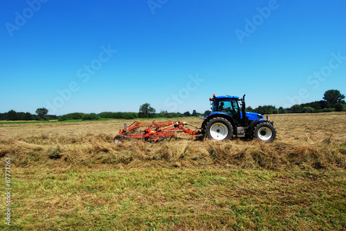 GERMANY - Farmer turns hay in summer