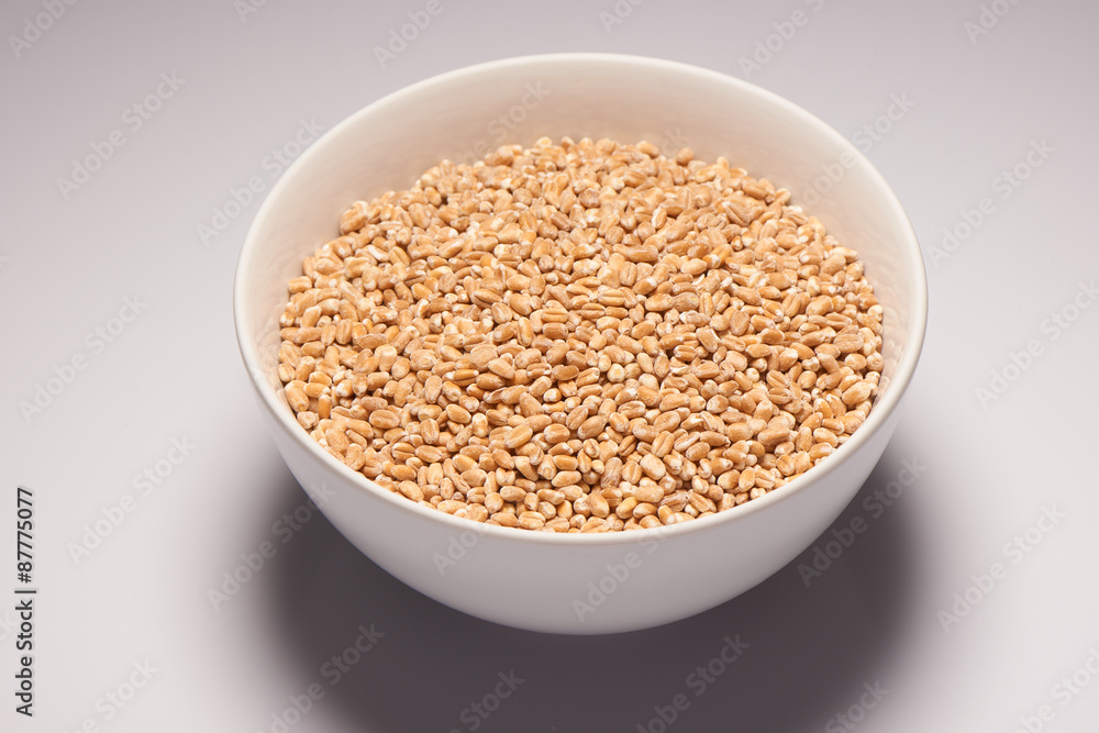 Barley in white ceramic bowl on white background Barley in white ceramic bowl on white background
