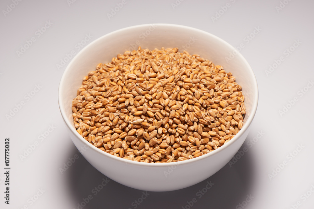 Oats in white ceramic bowl on white background Oats in white ceramic bowl on white background