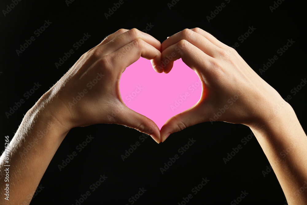 Fototapeta premium Human hands making heart on black background