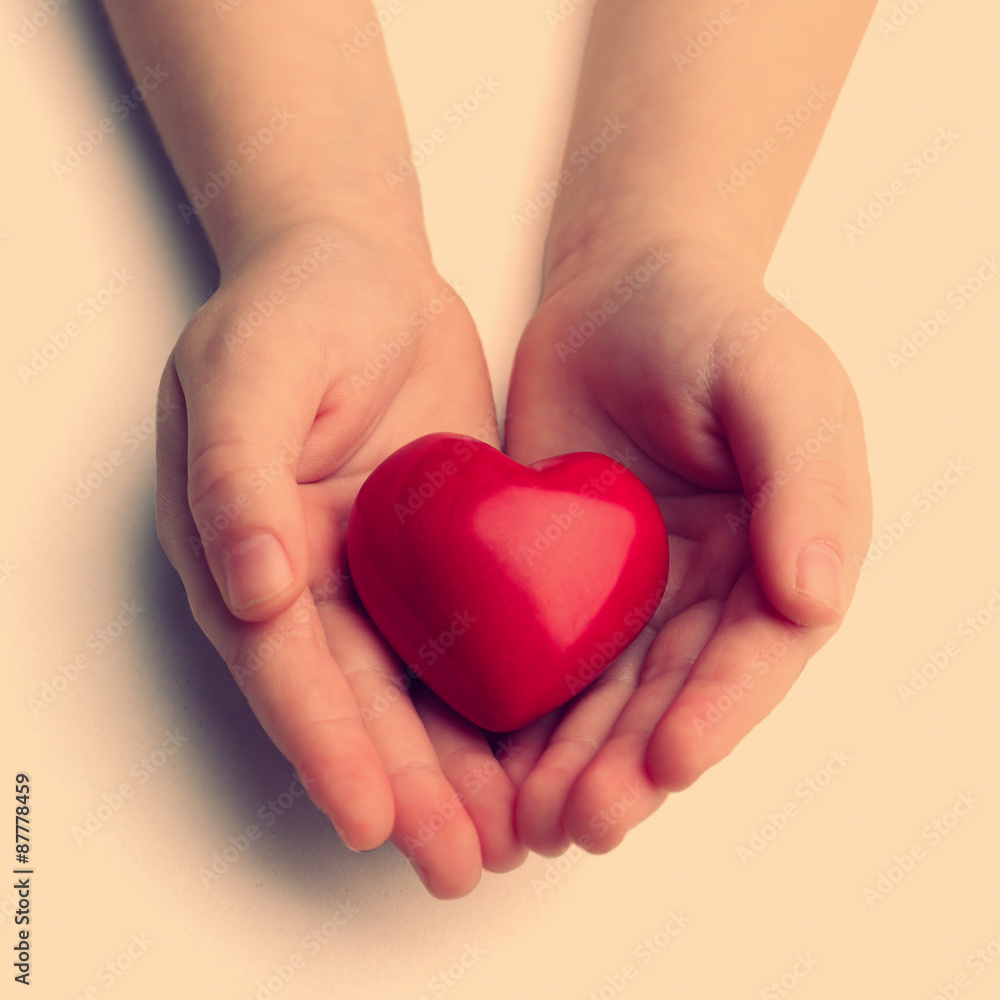 Fototapeta premium Heart in child hands on light background