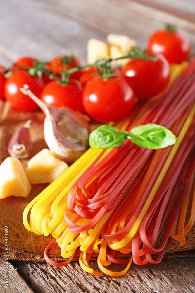 Pasta with cherry tomatoes and other ingredients on wooden table background