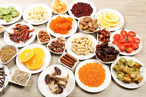 Different products on saucers on wooden table, closeup