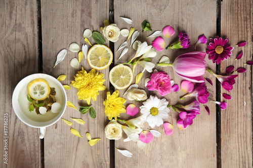 Cup of herbal tea with beautiful flowers, on wooden background