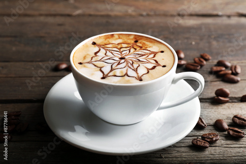 Fototapeta Naklejka Na Ścianę i Meble -  Cup of latte art coffee with grains on wooden background
